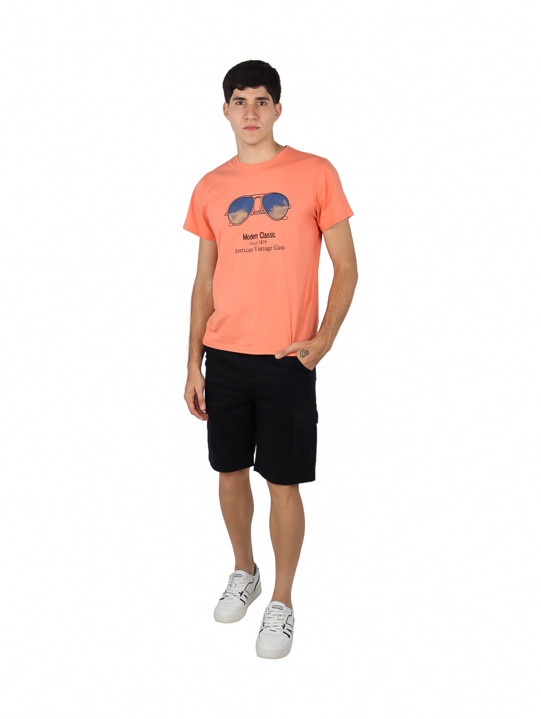 Hombre vistiendo bermudas cargo color negro con cinturón integrado y calzado blanco.