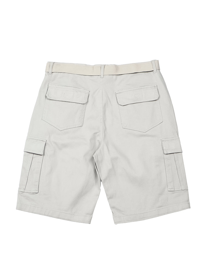 Hombre modelando bermudas color gris con bolsillos laterales y camiseta gris.