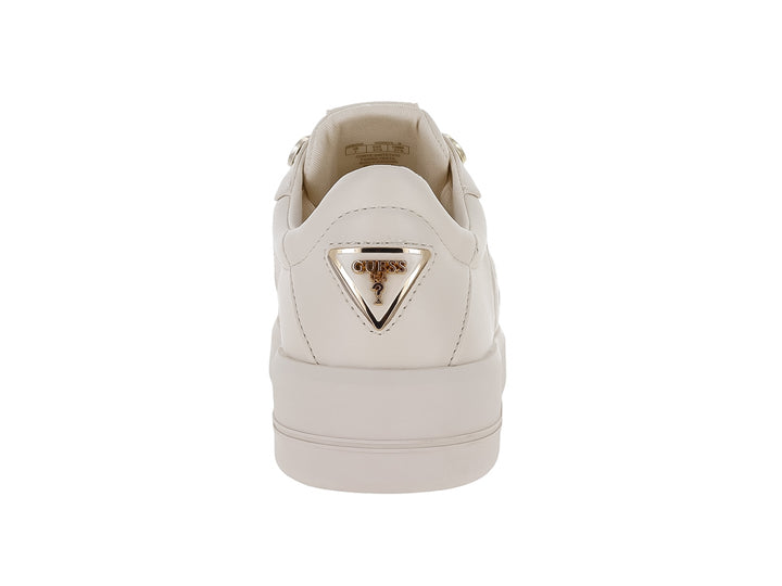 Tenis Guess color crema con suela de plataforma y detalles grabados en el lateral.