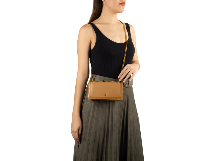 Bolso de hombro Cloe color café con cadena dorada y detalles texturizados en los bordes.