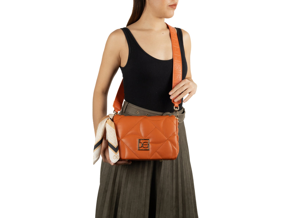 Bolso de hombro Cloe color tan con diseño acolchado, detalles en cadena dorada y un pañuelo decorativo lateral.