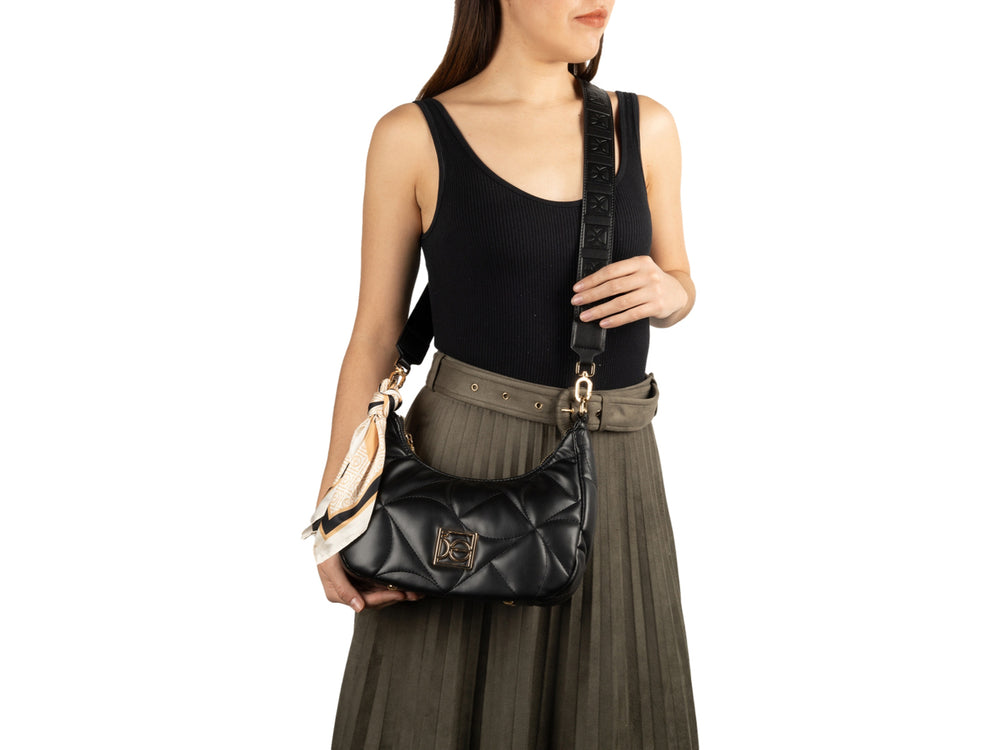 Bolso hobo negro acolchado con asa de cadena dorada y un pañuelo decorativo.