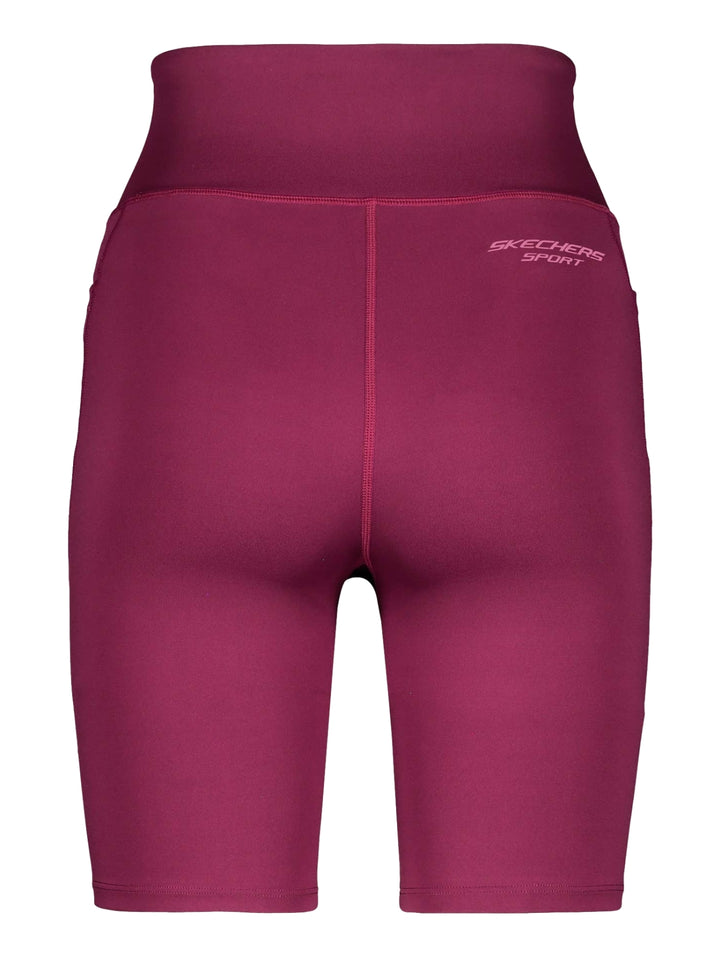 Mujer vistiendo biker shorts deportivos de color fucsia de la marca Skechers.