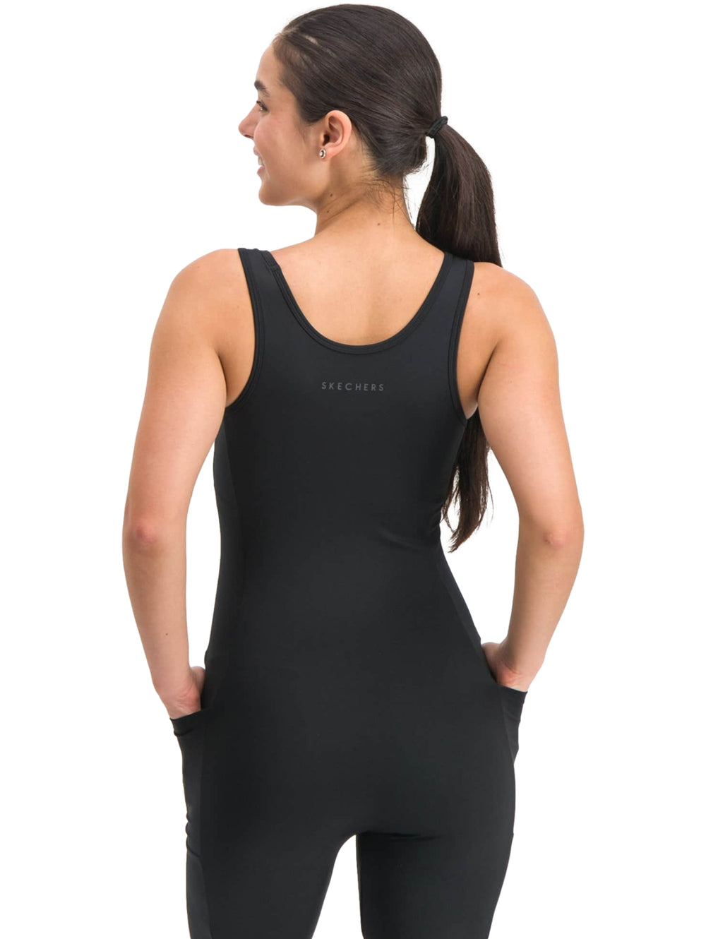 Mujer vistiendo un enterizo deportivo de color negro sin mangas.