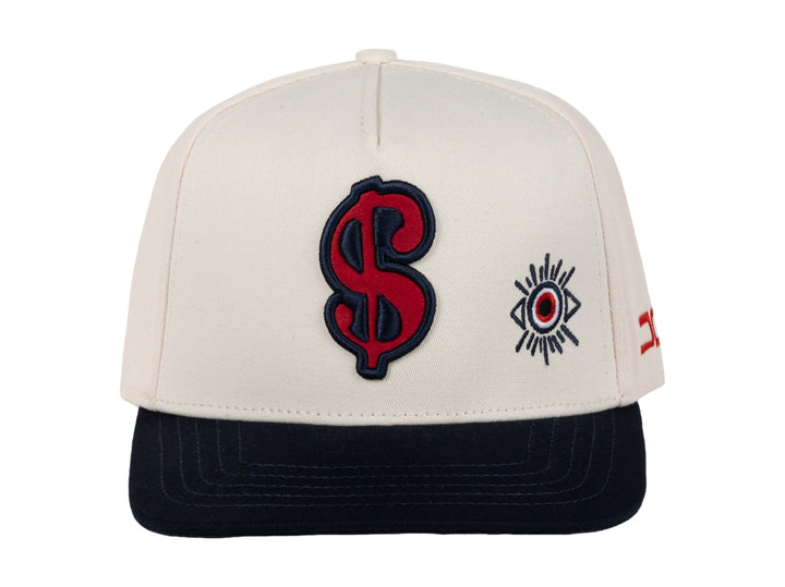 Gorra snapback color beige con visera azul marino y bordados en rojo y azul.