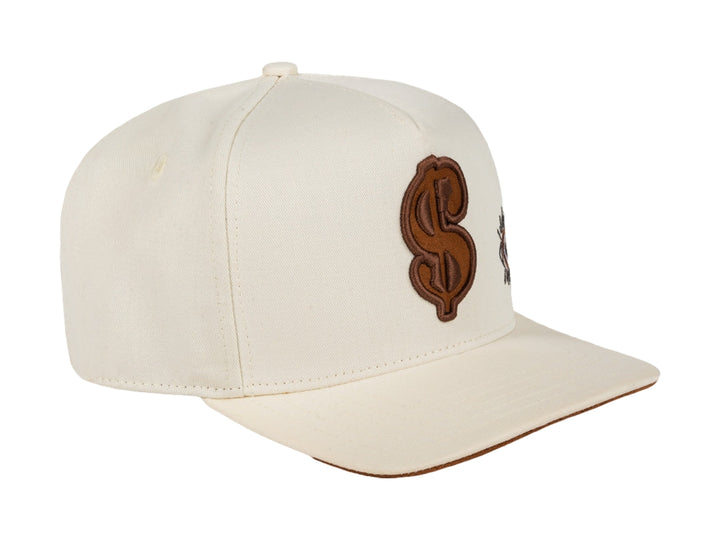 Gorra snapback color beige con bordados en marrón, incluyendo un símbolo de dólar y un ojo.