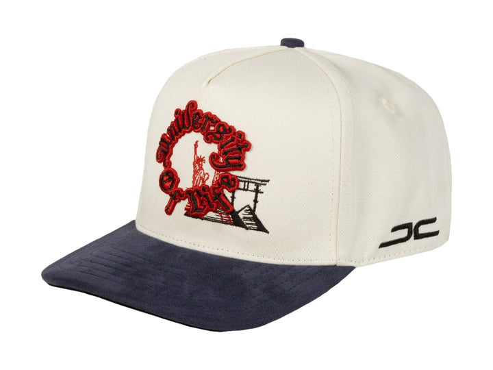 Gorra snapback JC Hats color beige con visera azul marino y bordado rojo frontal.