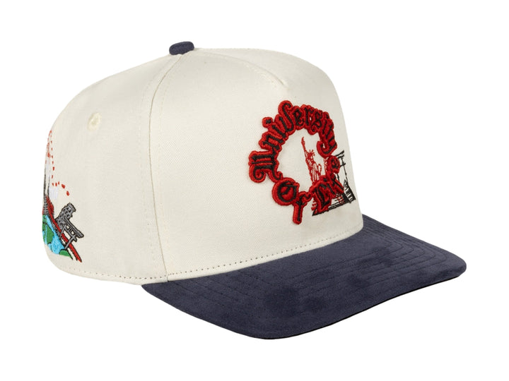 Gorra snapback JC Hats color beige con visera azul marino y bordado rojo frontal.