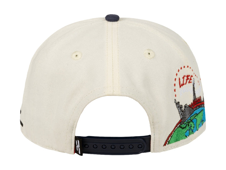 Gorra snapback JC Hats color beige con visera azul marino y bordado rojo frontal.