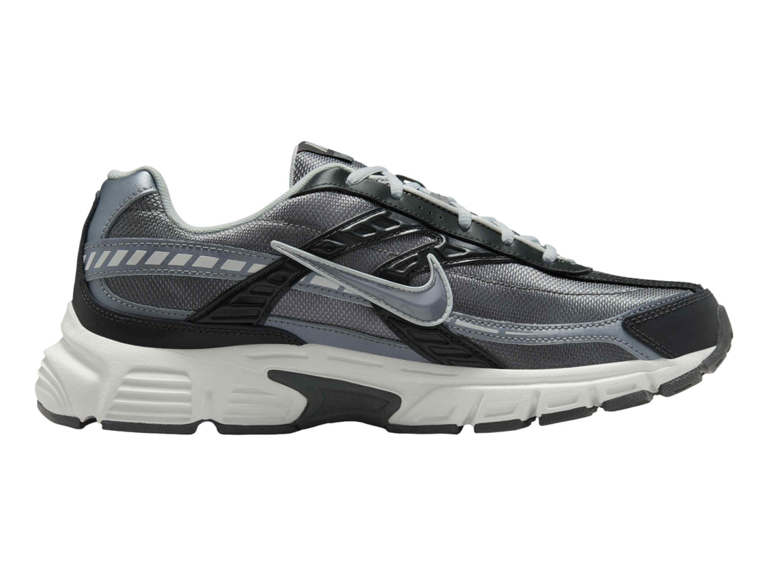 Tenis deportivos Nike en color gris antracita y blanco con detalles en gris claro.