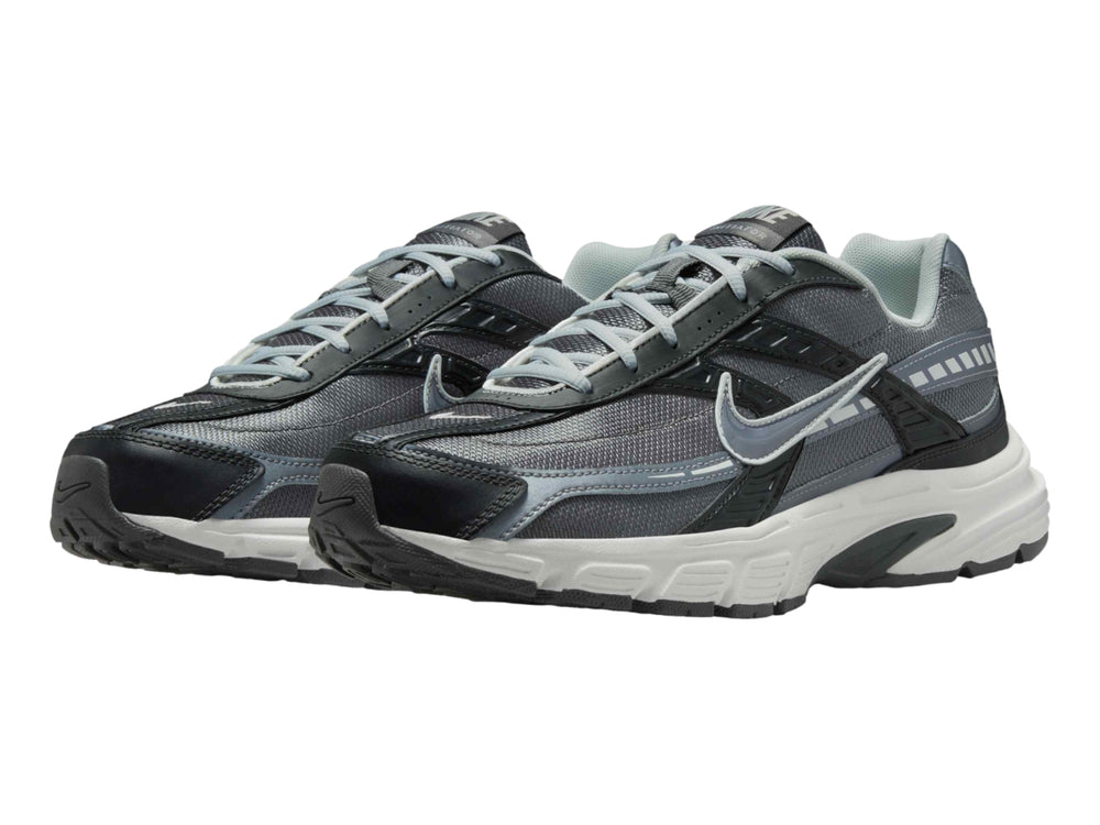 Tenis deportivos Nike en color gris antracita y blanco con detalles en gris claro.