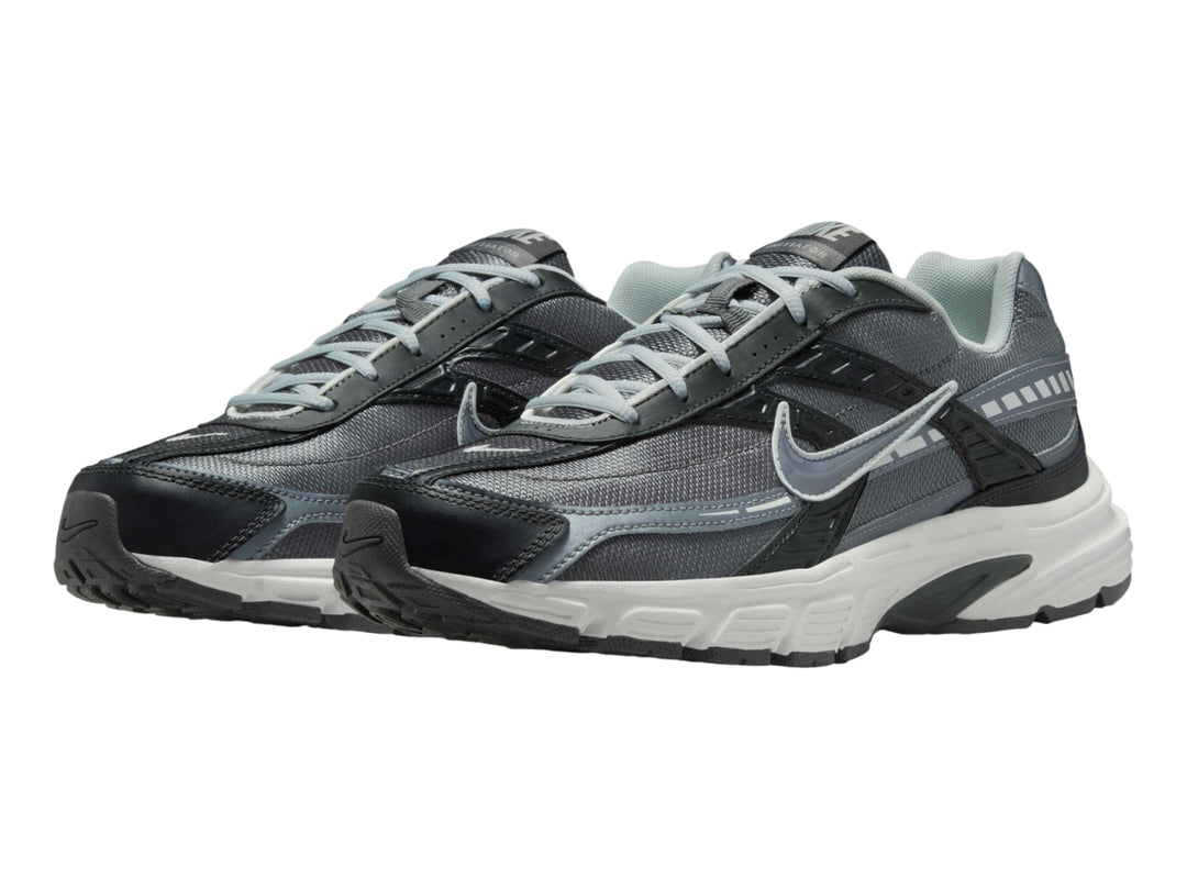 Tenis deportivos Nike en color gris antracita y blanco con detalles en gris claro.