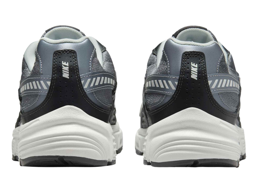 Tenis deportivos Nike en color gris antracita y blanco con detalles en gris claro.