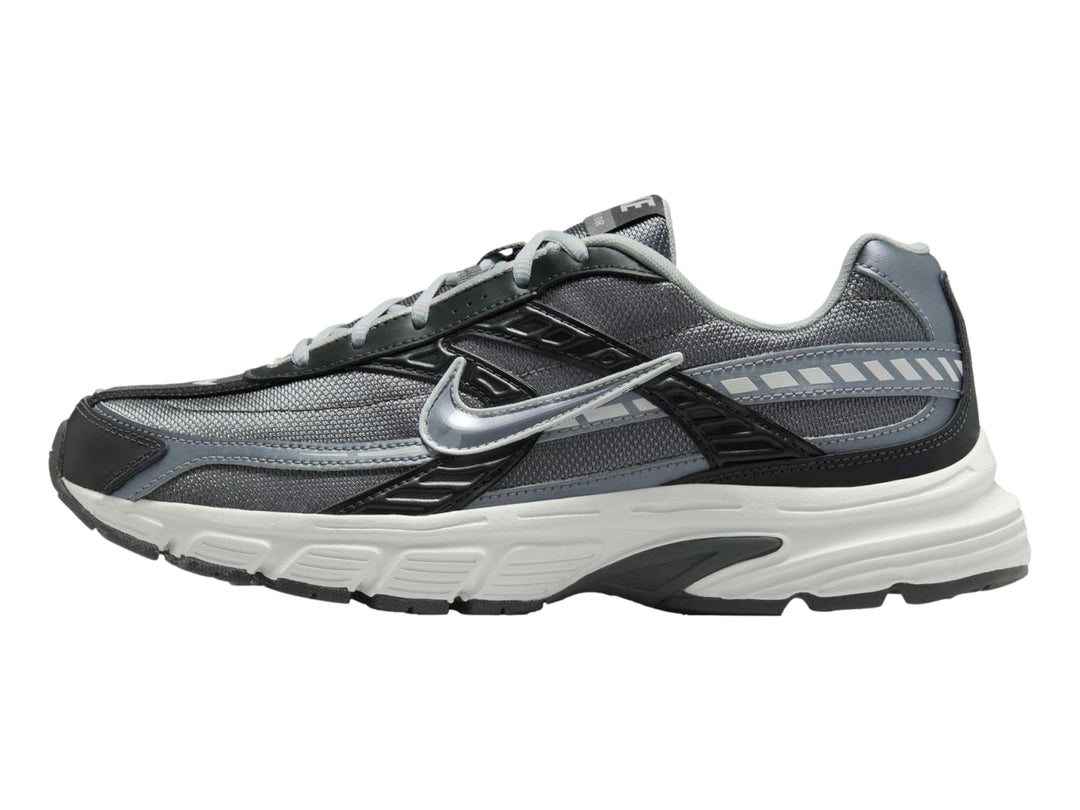 Tenis deportivos Nike en color gris antracita y blanco con detalles en gris claro.