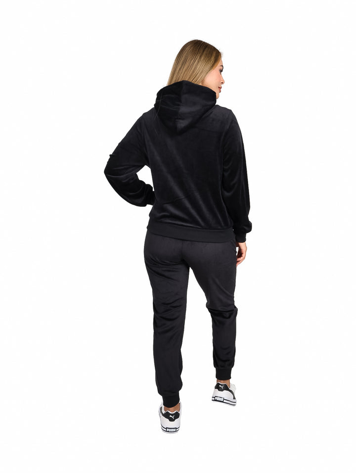 Mujer vistiendo un conjunto de sudadera con capucha y pantalón en color negro.