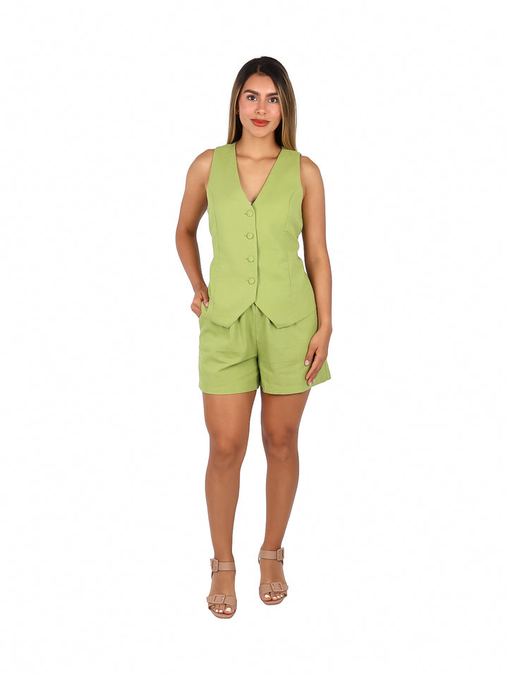 Mujer vistiendo un conjunto de dos piezas color verde lima compuesto por un chaleco con botones y shorts.