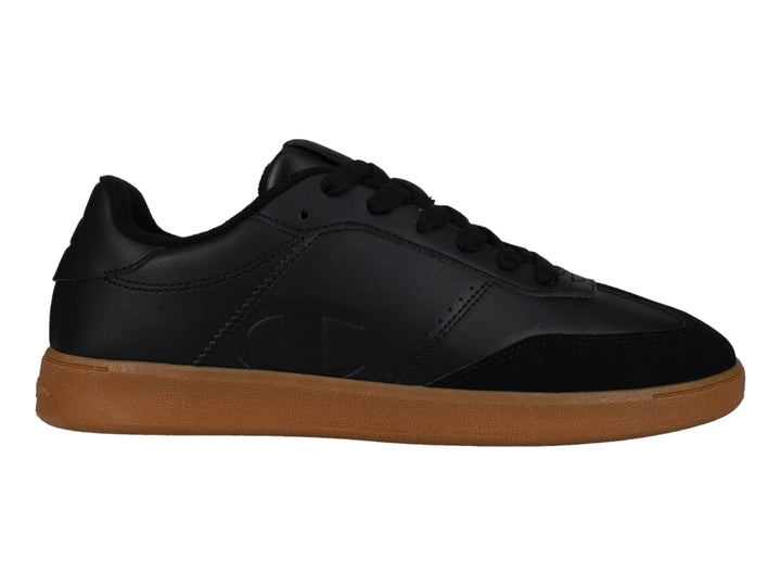 Tenis Champion color negro con suela de goma café, estilo deportivo y casual.