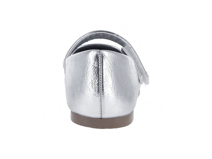 Zapato plano para niña en color plata metálico con correa de ajuste y suela marrón.