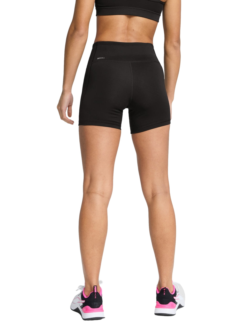 Mujer vistiendo shorts deportivos ajustados de cintura alta color negro marca PUMA.