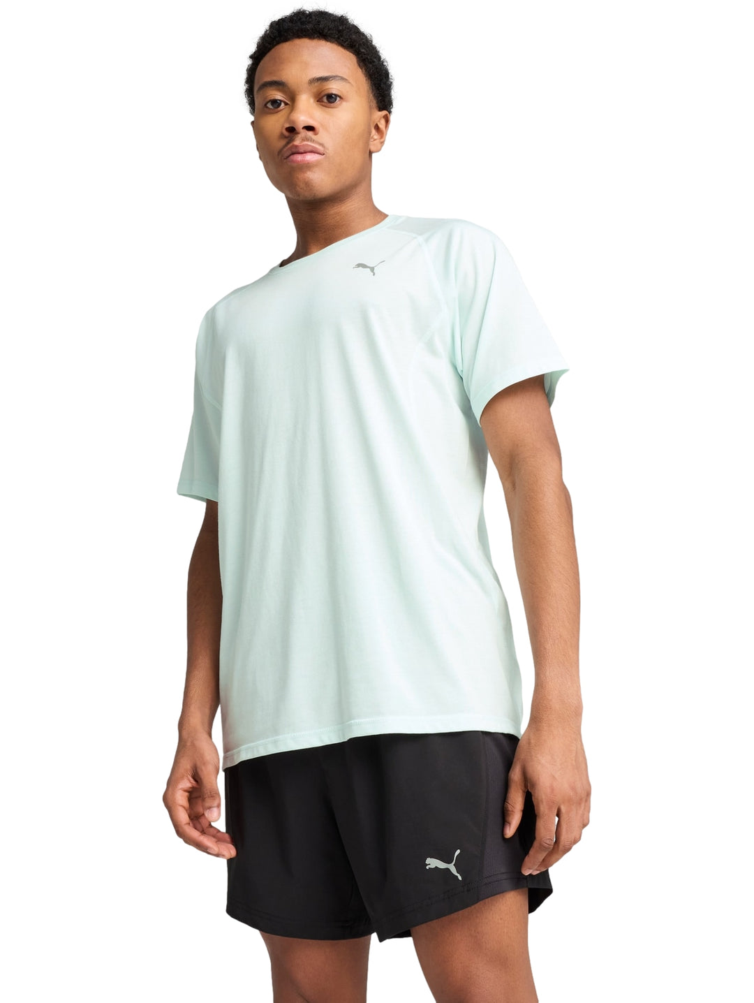 Hombre vistiendo playera deportiva Puma color azul claro y shorts negros.