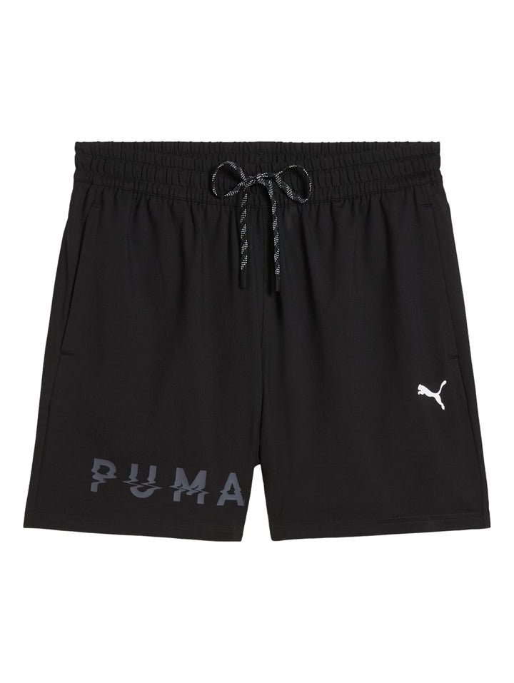 Hombre vistiendo shorts deportivos Puma color negro con logotipo blanco lateral.