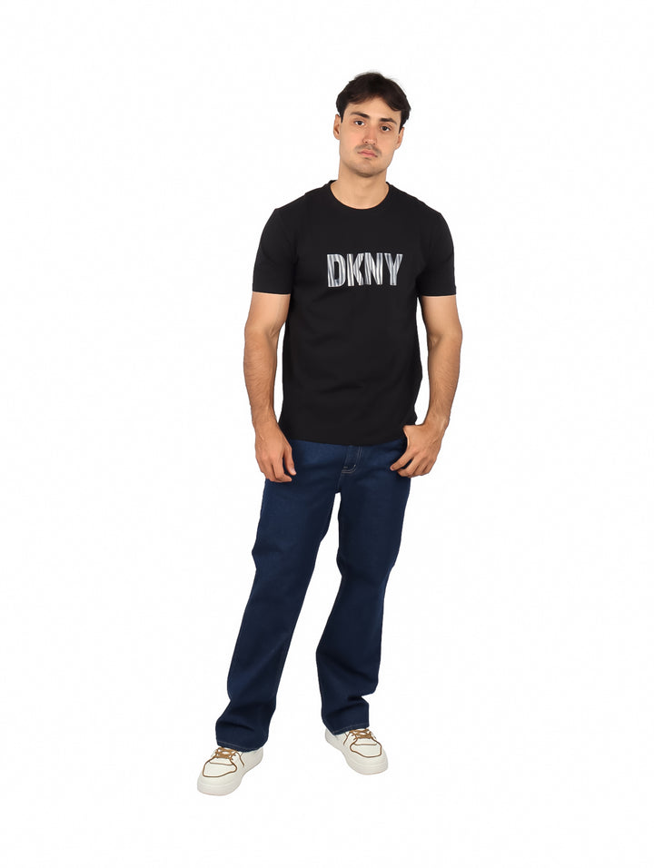 Hombre vistiendo una camiseta negra de manga corta con el logotipo de DKNY en el pecho.