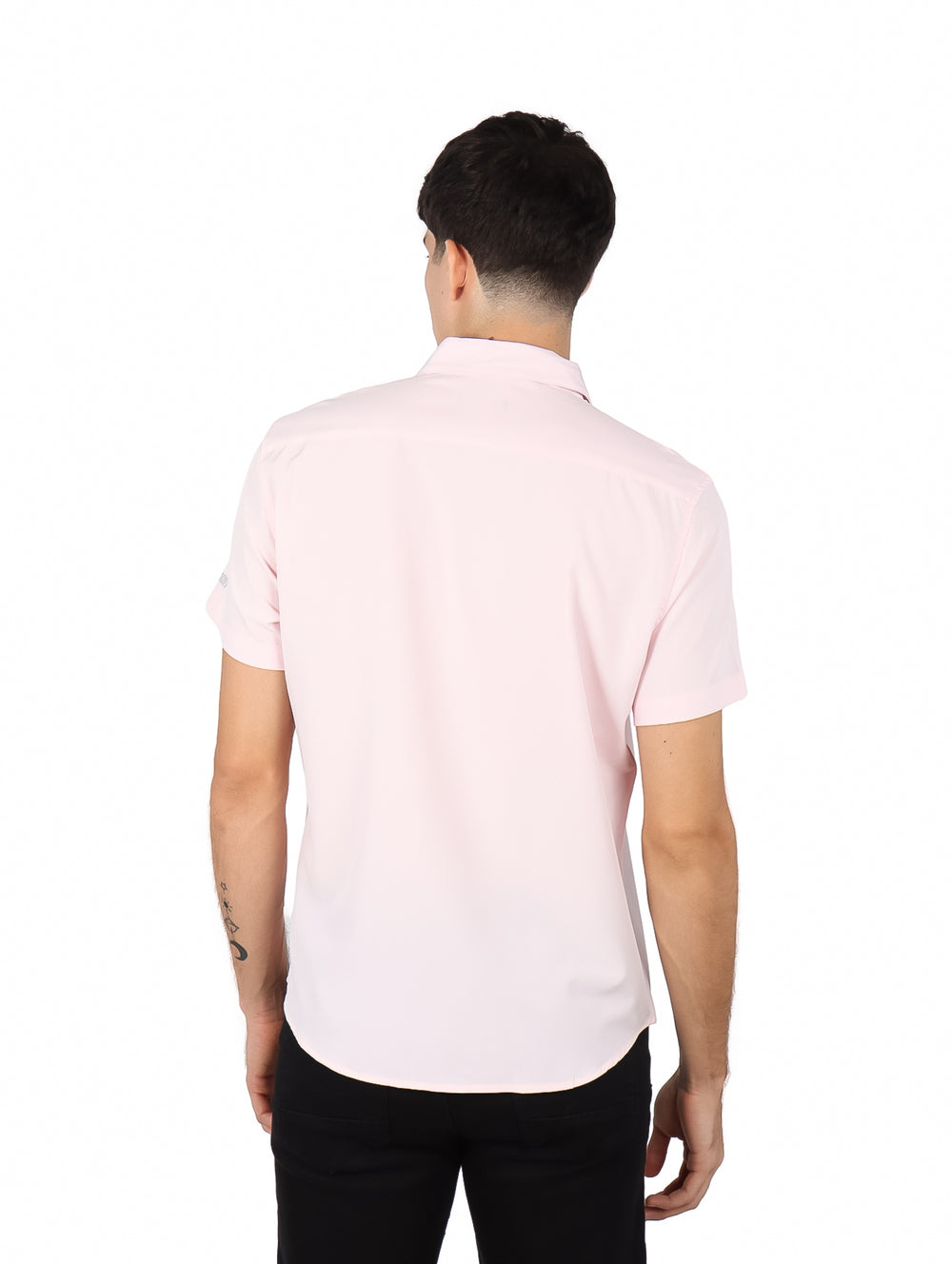 Hombre vistiendo una camisa de manga corta color rosa claro con cuello y botones.