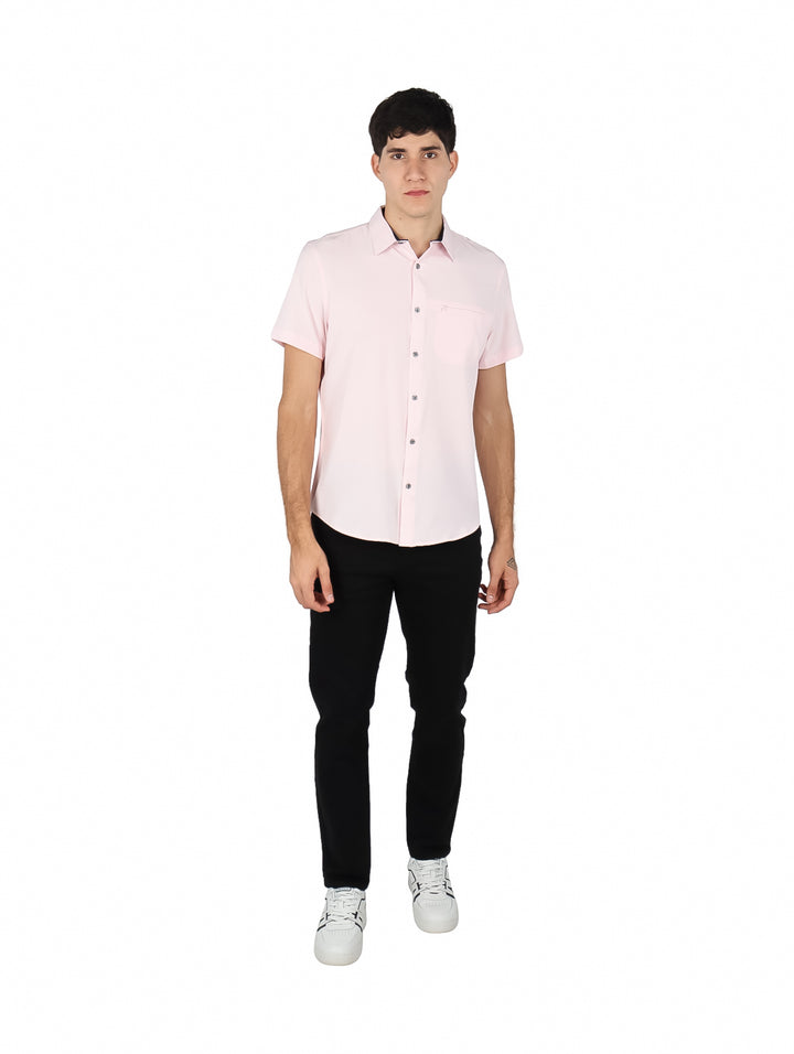 Hombre vistiendo una camisa de manga corta color rosa claro con cuello y botones.