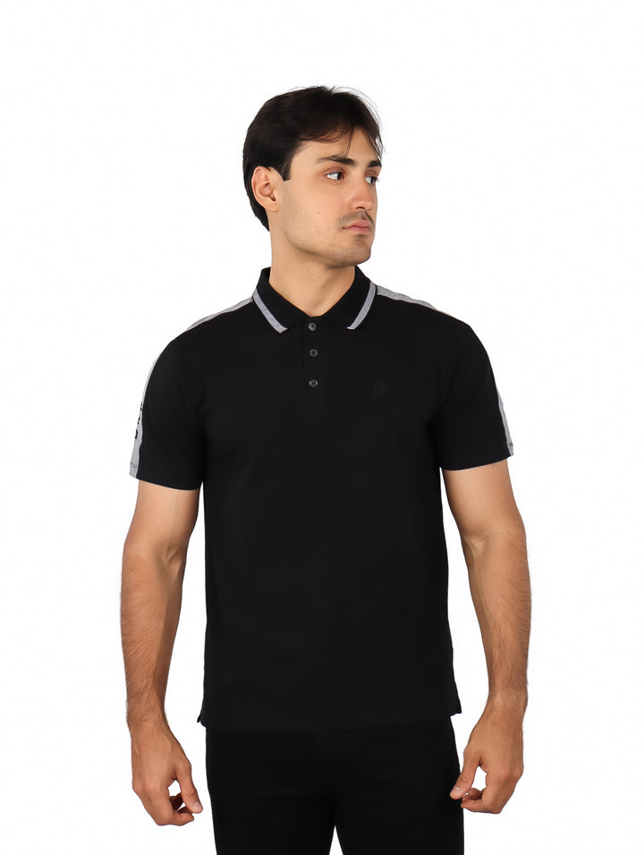 Hombre vistiendo una playera polo color negro con detalles en gris en los hombros y cuello.