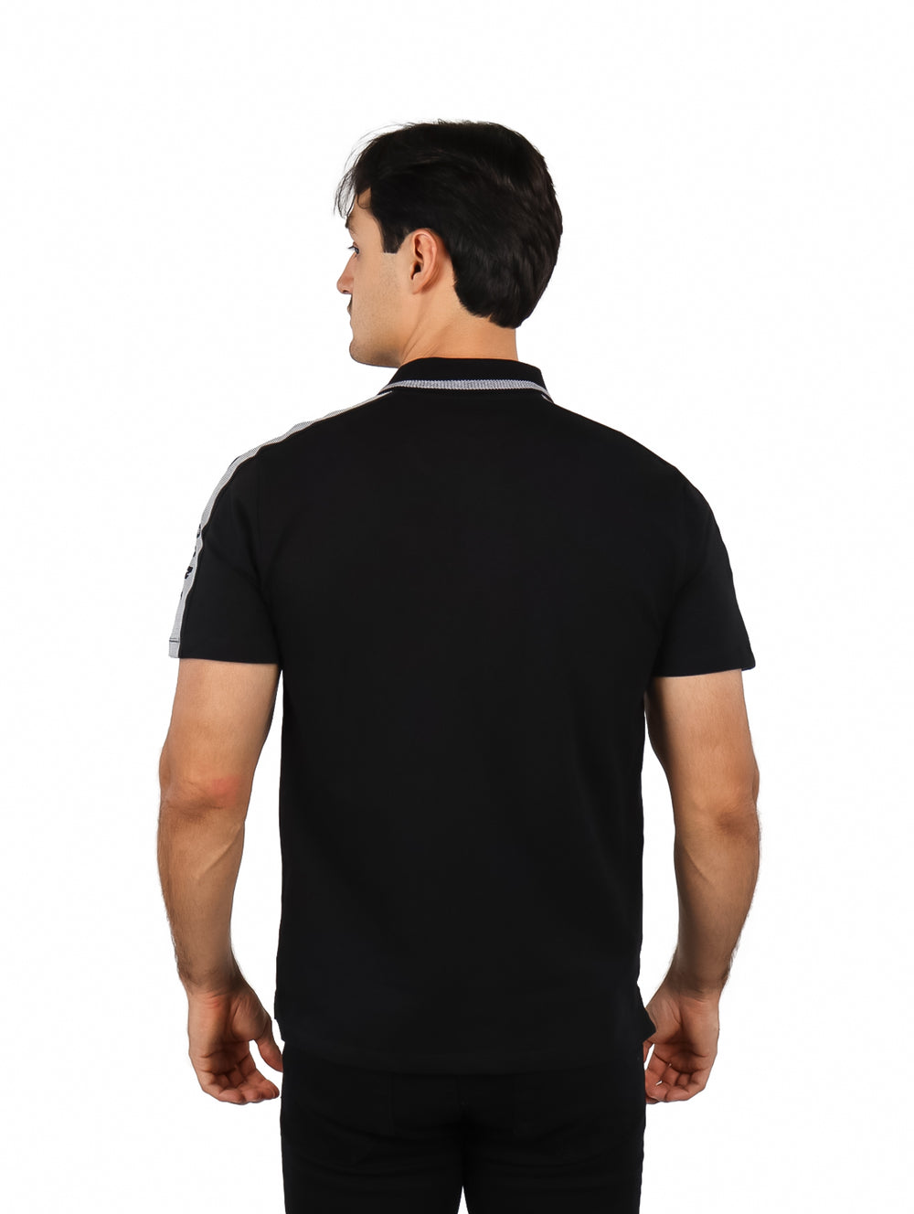 Hombre vistiendo una playera polo color negro con detalles en gris en los hombros y cuello.