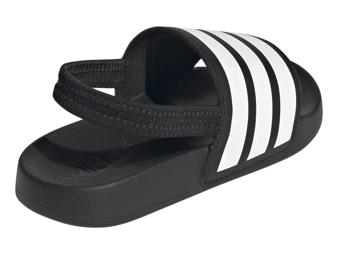 Sandalias Adidas Adilette negras para niños con tres franjas blancas en la correa.