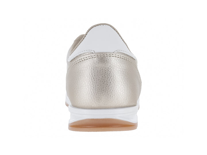 Tenis deportivos color oro con detalles y suela blanca.