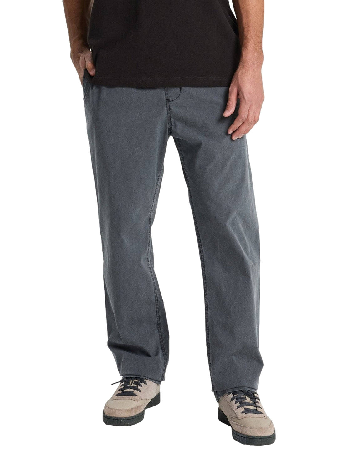 Hombre vistiendo pantalón largo recto de color negro marca Quiksilver.