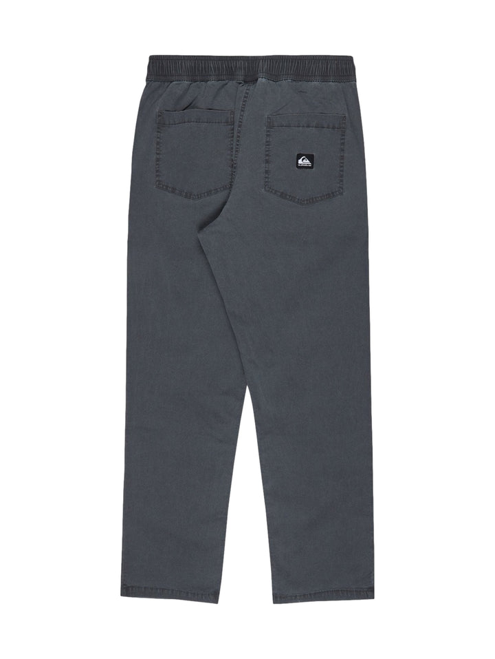 Hombre vistiendo pantalón largo recto de color negro marca Quiksilver.