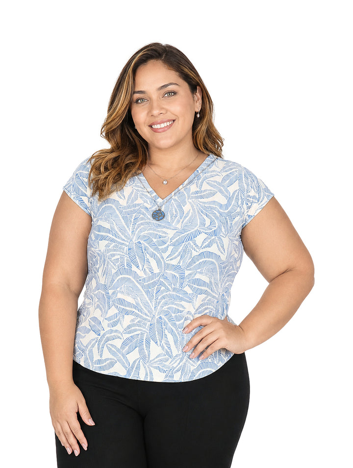 Mujer vistiendo blusa azul y blanca con estampado de hojas y manga corta.