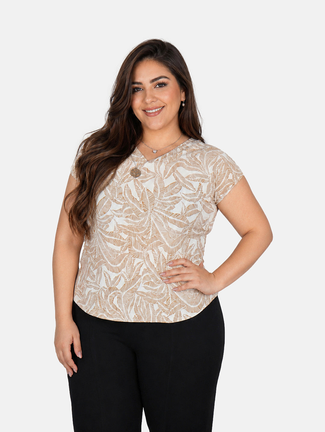 Mujer vistiendo blusa estampada color kaki con diseño de hojas y pantalones negros.