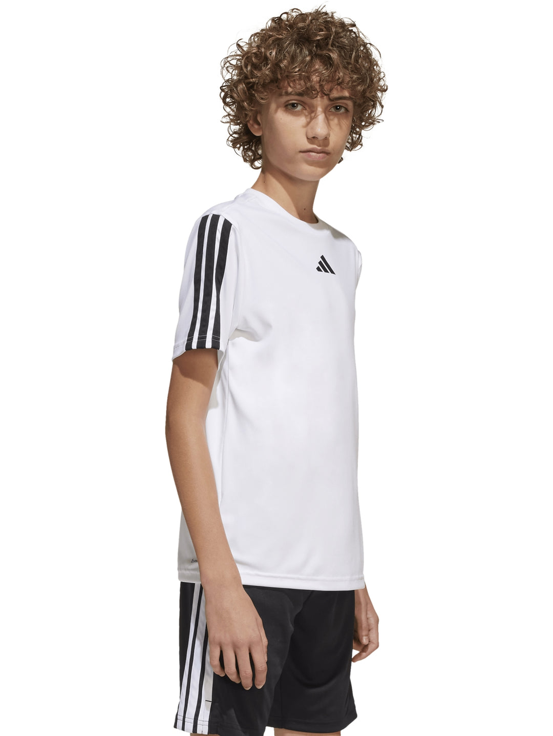 Niño vistiendo playera deportiva blanca Adidas con tres franjas negras en las mangas.