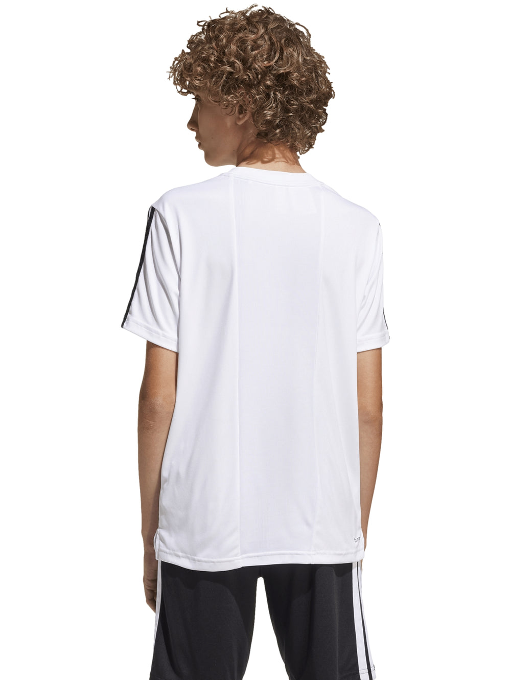 Niño vistiendo playera deportiva blanca Adidas con tres franjas negras en las mangas.