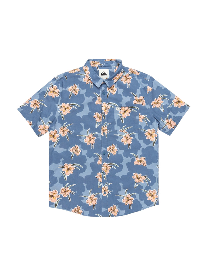 Hombre vistiendo camisa de manga corta azul con estampado floral en tonos crema.