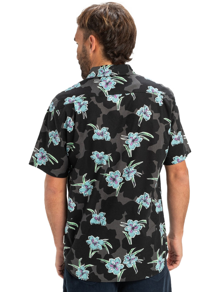 Camisa negra de manga corta con estampado floral en tonos azules y verdes para hombre.