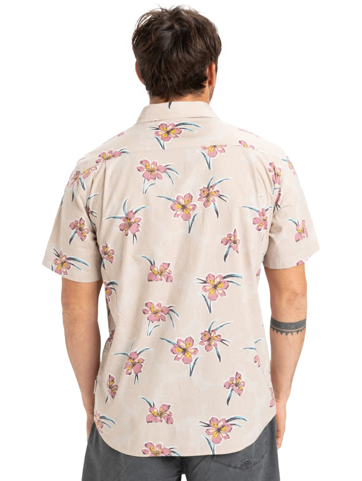 Camisa de manga corta color beige con estampado de flores en tonos rosa y azul.