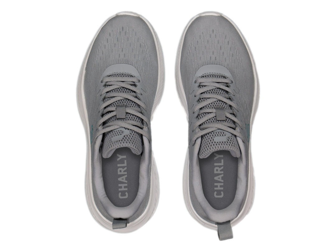 Tenis deportivos Charly color gris con suela blanca y logotipo en azul claro.