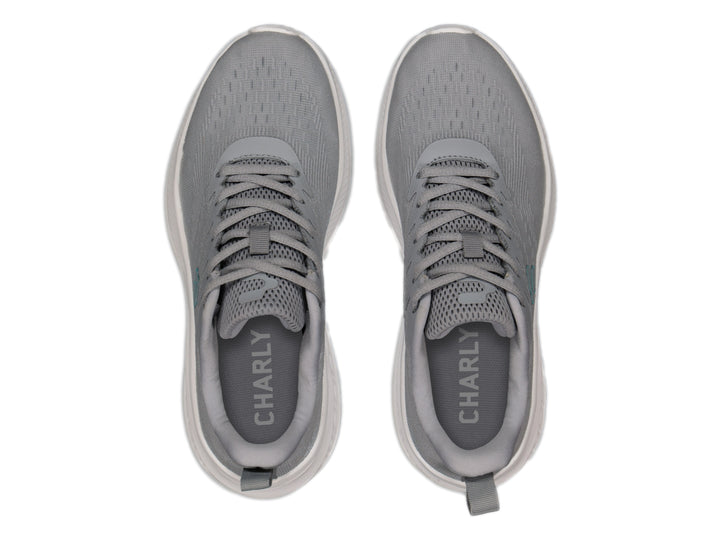 Tenis deportivos Charly color gris con suela blanca y logotipo en azul claro.