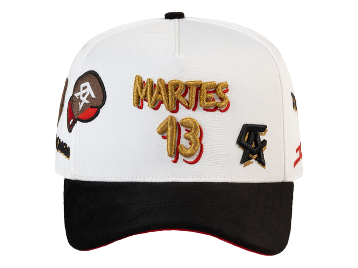Gorra JC Hats blanca con visera negra y detalles bordados en dorado, negro y rojo.