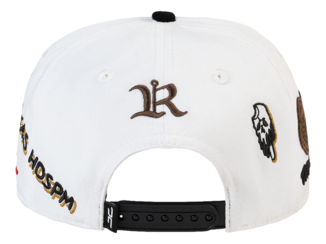 Gorra JC Hats blanca con visera negra y detalles bordados en dorado, negro y rojo.