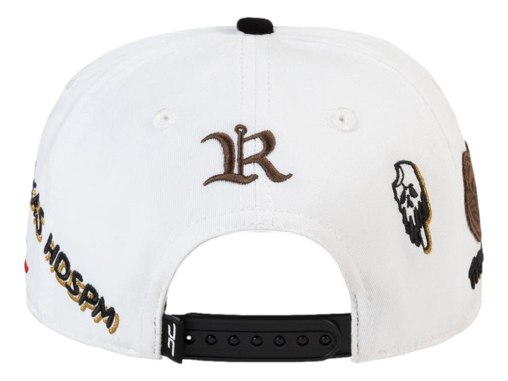 Gorra JC Hats blanca con visera negra y detalles bordados en dorado, negro y rojo.