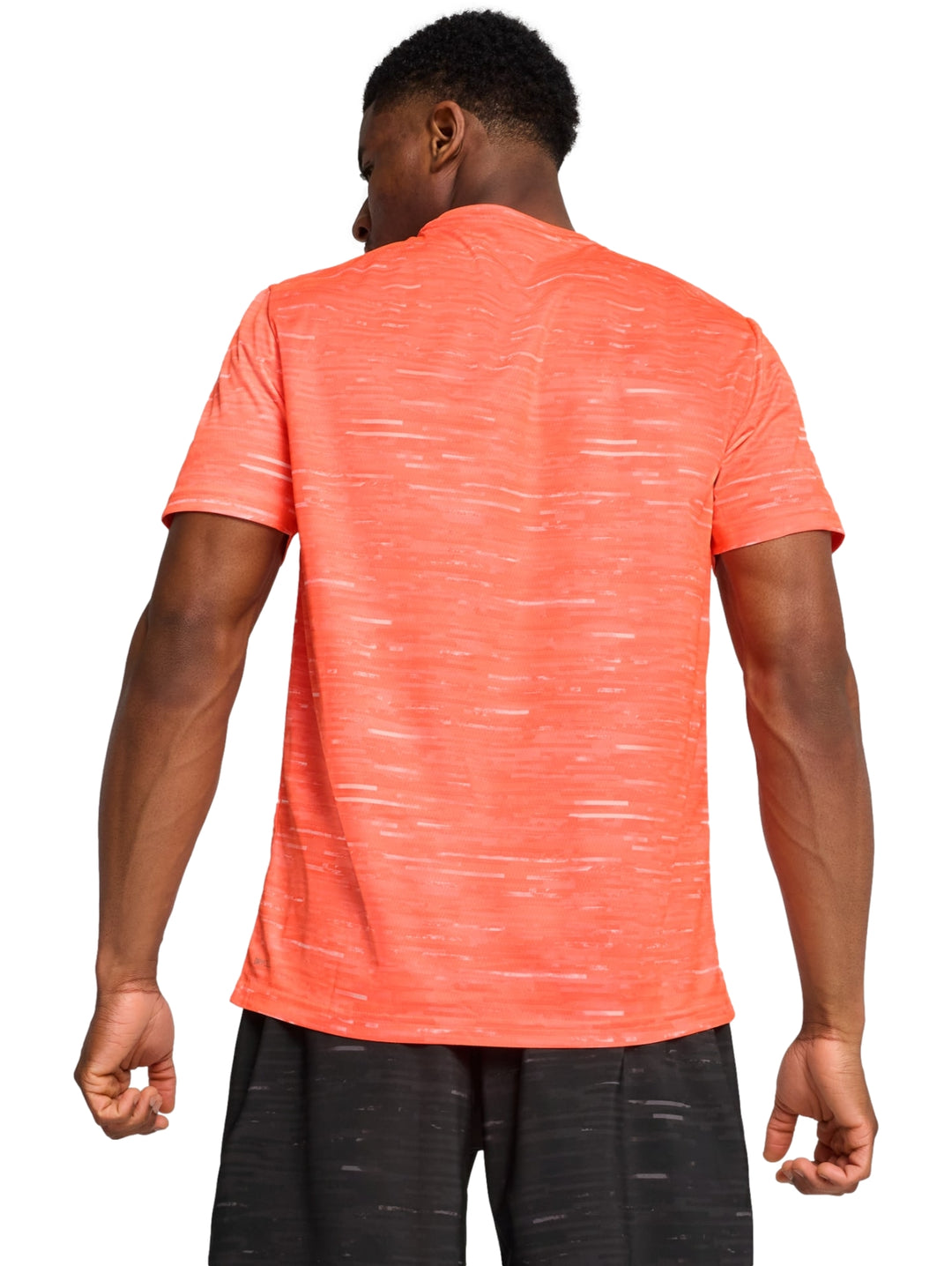 Hombre vistiendo una playera deportiva PUMA de color rojo brillante con cuello redondo y manga corta.