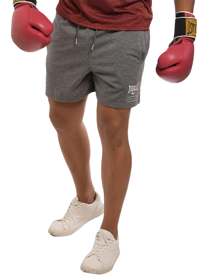 Hombre vistiendo shorts deportivos color gris oxford de la marca Everlast.