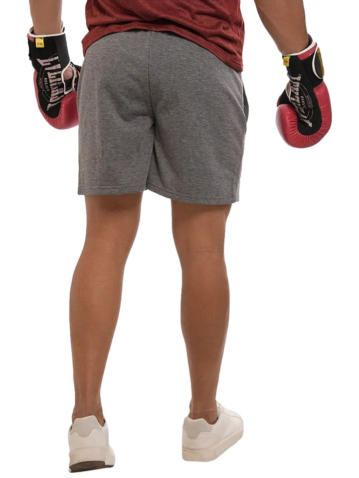 Hombre vistiendo shorts deportivos color gris oxford de la marca Everlast.