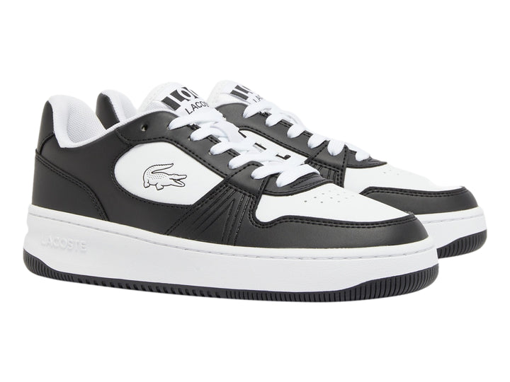 Tenis deportivos Lacoste para niño en colores blanco y negro con logotipo del cocodrilo lateral.